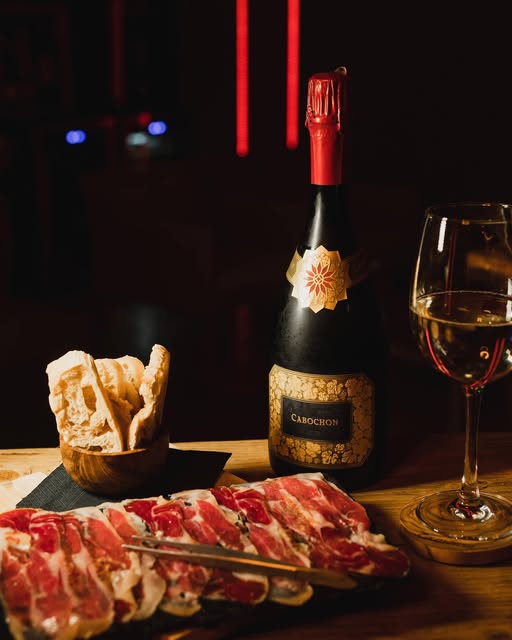 Tagliere di salumi e pane con un calice di bollicine